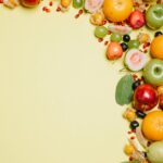 Fresh and colorful assortment of tropical and exotic fruits arranged on a bright yellow background.